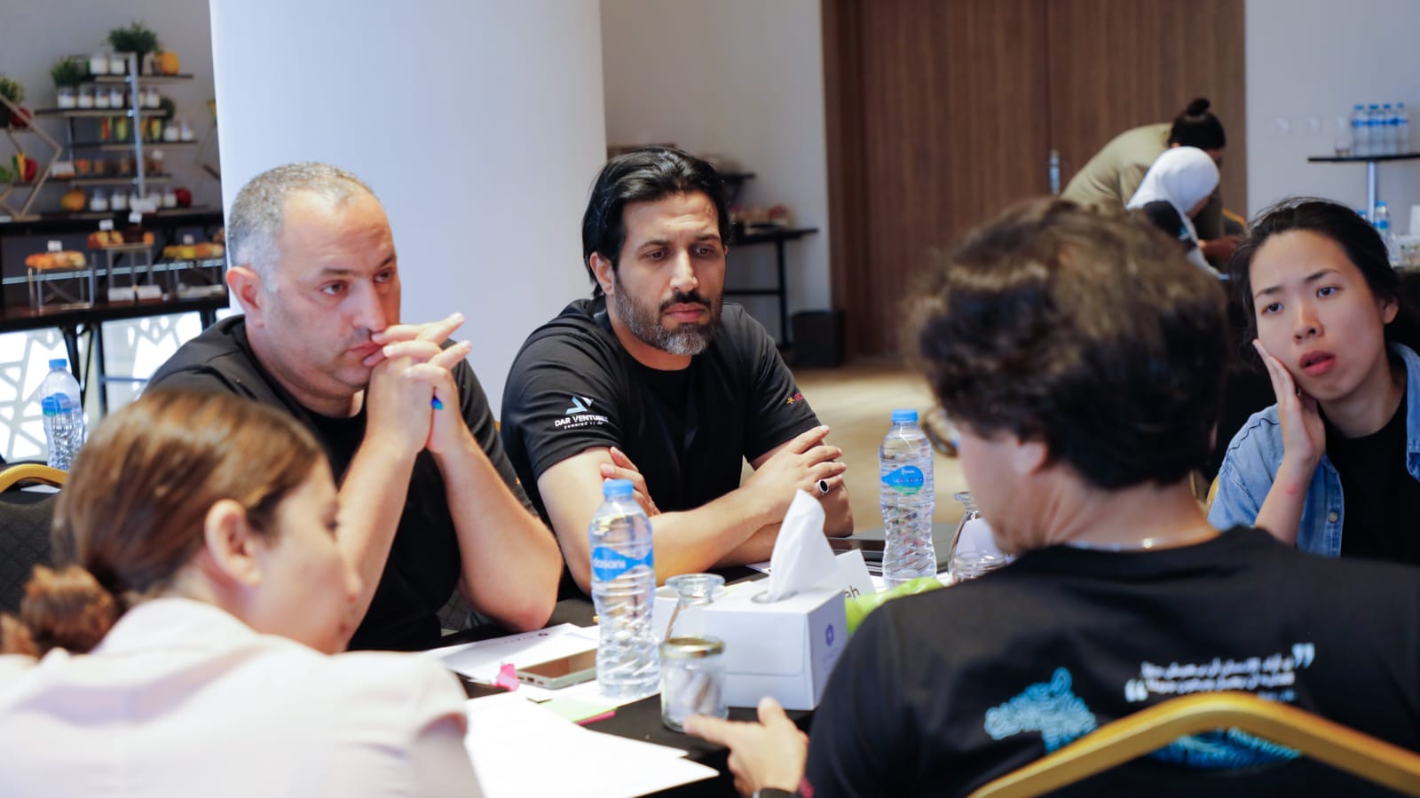 Five people in close discussion around a table